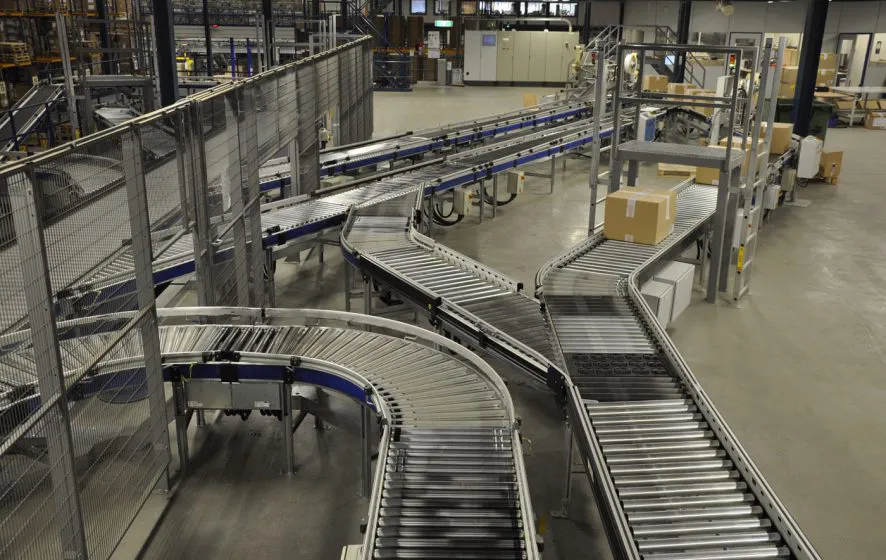 Diverse aaneengesloten rollenbanen in magazijn dat pakketen transporteerd.